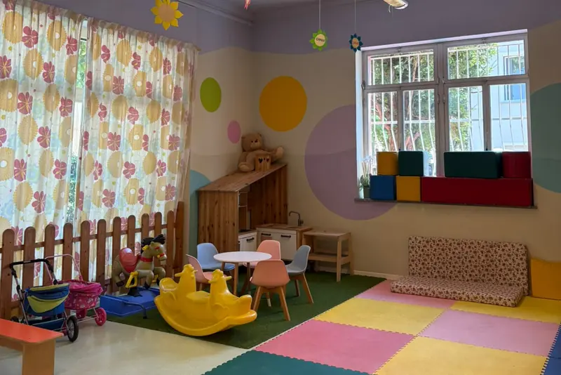 Sala gioco della sede di Cherasco con tappeti morbidi e cucina in legno